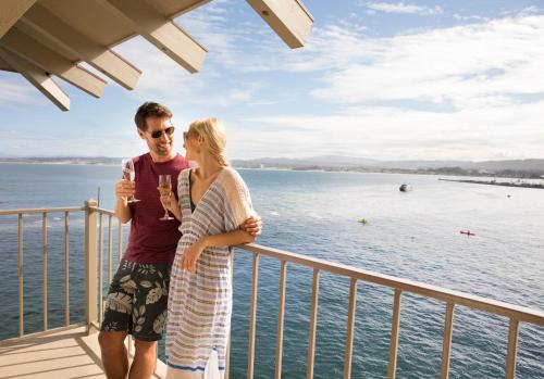 a man and a woman standing on a deck near the water at Monterey Plaza Hotel & Spa in Monterey