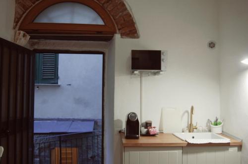 una cucina con lavandino e una TV a parete di Il Soppalco a Corniglia