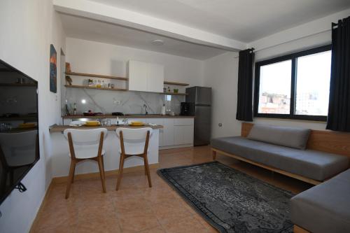 uma cozinha e sala de estar com mesa e cadeiras em Rondine Studio Apartment em Tirana