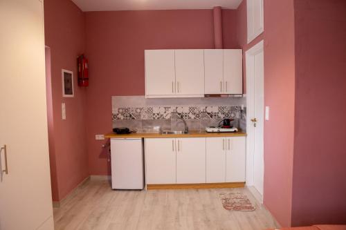 a kitchen with white cabinets and a sink at TRADITIONAL HOUSE ALEPIS IN AREOPOLIS in Areopolis