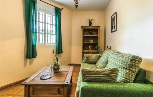 a living room with a green couch and a table at Gorgeous Home In Iznajar in Iznájar
