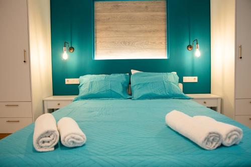 a bedroom with a blue bed with towels on it at TRADITIONAL HOUSE ALEPIS IN AREOPOLIS in Areopolis