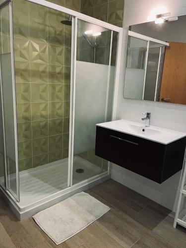 a bathroom with a glass shower and a sink at Casa Marta e Casa Francisco in Olhão