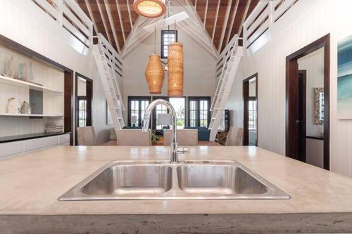 a kitchen with a stainless steel sink in a room at Athena's Mahogany House and The PoolClub at Mahogany Bay! in San Pedro