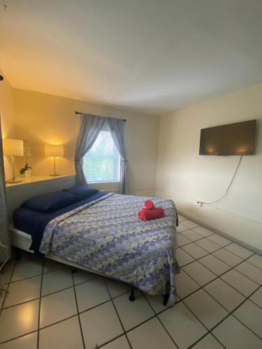 a bedroom with a bed with a red hat on it at Hoosville Hostel (Formerly The Everglades Hostel) in Florida City