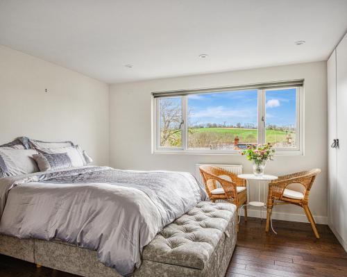 a bedroom with a bed and a table and chairs at Maya residence in Bourne End