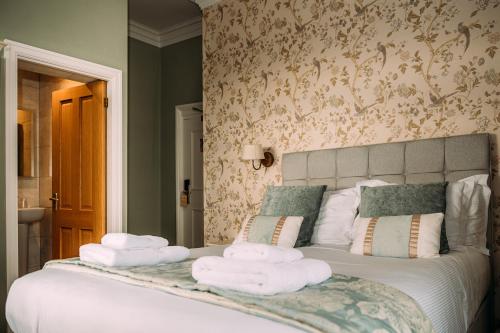 a bedroom with a bed with towels on it at The Queens Hotel in Lytham St Annes