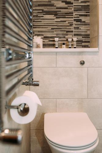 a bathroom with a toilet and a roll of toilet paper at The Queens Hotel in Lytham St Annes