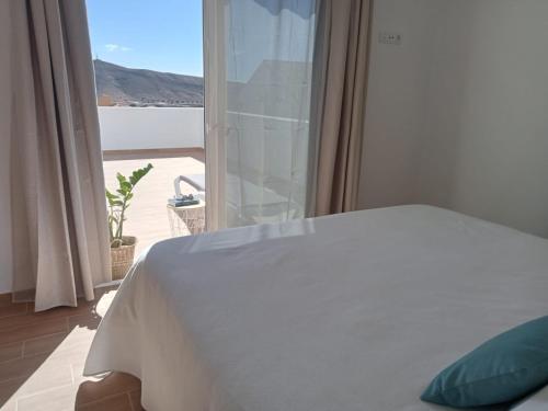 a bedroom with a bed and a window with a view at Apartamento Onix Jacuzzi in Tarajalejo