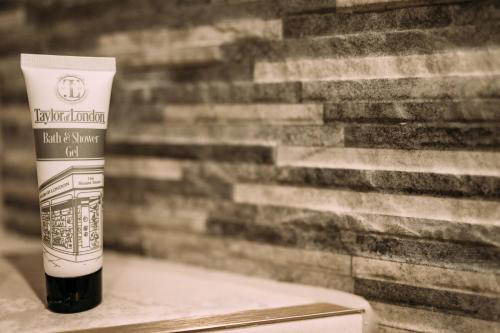 a bottle of hair sunscreen sitting next to a wall at The Queens Hotel in Lytham St Annes