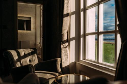 a window with a table and chairs looking out at the ocean at The Queens Hotel in Lytham St Annes