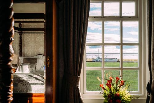 ventana con vistas a una cama y un campo en The Queens Hotel, en Lytham St Annes