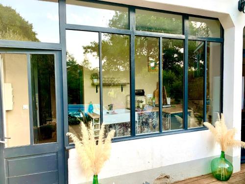 frente a una tienda con grandes ventanas de cristal y jarrones en Studio Muret atypique en Muret