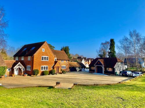 a large brick house with a large driveway at Hillside Farm Barn in Woking