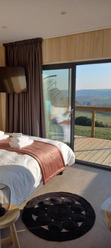 a bedroom with a bed and a balcony with a view at Demeure de la Garenne in Montmirail