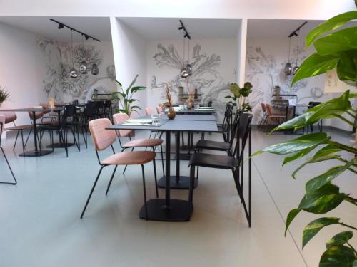 une salle à manger avec des tables, des chaises et des plantes dans l'établissement Site78, à Puurs