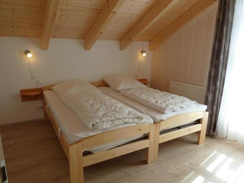 sypialnia z łóżkiem w pokoju z drewnianym sufitem w obiekcie Ferienhaus Nr 17A3, Feriendorf Hagbügerl, Bayr Wald w mieście Waldmünchen