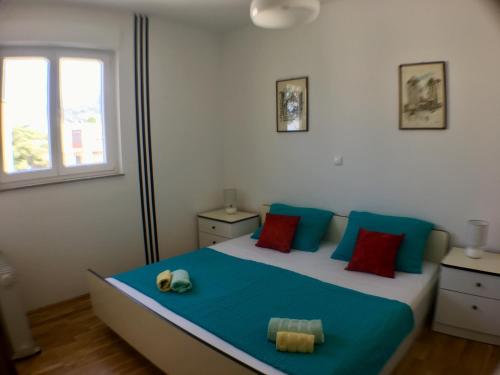 um quarto com uma cama grande com almofadas azuis e vermelhas em Apartment Popeye em Makarska
