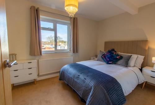 a bedroom with a bed and a window at Cottage On The Quay in Wroxham