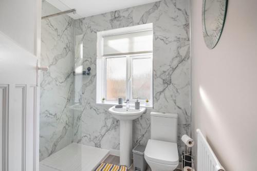 łazienka z umywalką, toaletą i oknem w obiekcie Spacious 3 Bed House, Netflix, Garden, Parking w Southampton