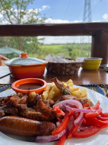 a plate of food with meat and vegetables on a table at Jey's Jiko Kitchen and Resort in Muhoroni