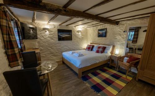 um quarto com uma cama e uma mesa num quarto em Townfoot Byre, Troutbeck - E.V friendly em Windermere