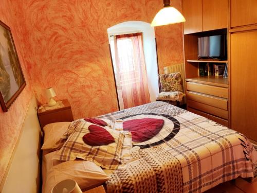 a small bedroom with a bed with a blanket at Mella house garden relax in Lezzeno