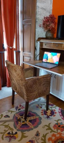 uma cadeira sentada em frente a uma mesa com um computador portátil em A Casa da Carballa em Ponteareas