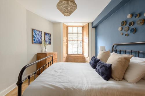 a bedroom with a bed with a blue wall at The Broughton St. Apartment (1BR) - New Town in Edinburgh