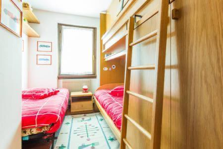 ein Schlafzimmer mit 2 Betten und einem Bücherregal in der Unterkunft Le Marmotte del Brenta in Carisolo