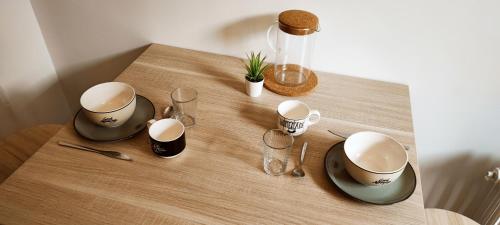 une table avec deux tasses et des verres dessus dans l'établissement Duplex cosy - Gare - Hyper centre - WIFI, à Angers