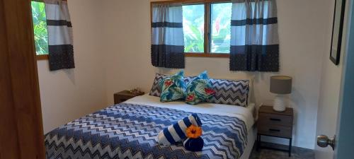 a bedroom with a bed with pillows and a window at Tropical Retreat Rarotonga in Rarotonga