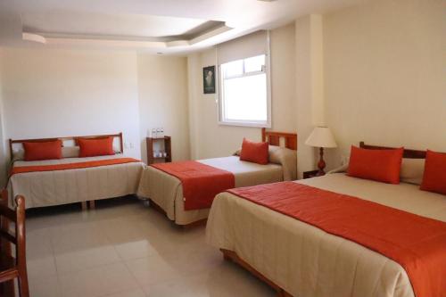 ein Hotelzimmer mit zwei Betten und einem Fenster in der Unterkunft Hotel Señorial Tlaxcala in Tlaxcala de Xicohténcatl