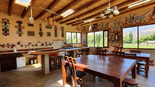 una sala da pranzo con tavolo e sedie in legno di Solar del Tropico a Huacalera