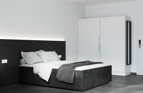 Schlafzimmer mit einem großen Bett mit einem schwarzen Kopfteil in der Unterkunft The Residences - Apartments Frankfurt in Offenbach