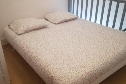 un lit avec deux oreillers dessus dans l'établissement NID DU MASSE AVEC PARKING, à Nantes