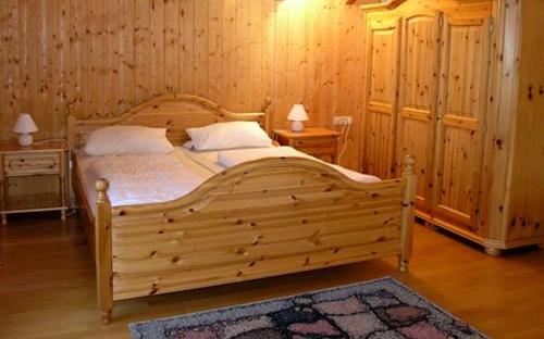 ein Schlafzimmer mit einem Holzbett in einem Zimmer mit Holzwänden in der Unterkunft Ferienhaus Nr 13A2, Feriendorf Hagbügerl, Bayr Wald in Waldmünchen
