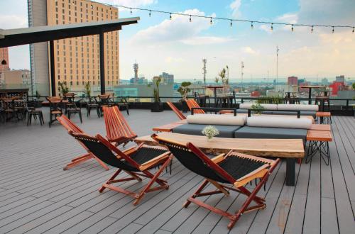 a patio with chairs and a table and a couch at Hotel B Urban Xaman by Fontán Reforma in Mexico City