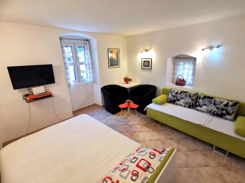 a living room with a couch and a tv at Old Town Boskovic Apartment in Kotor