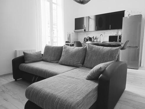 un salon avec un canapé et une cuisine dans l'établissement T3 Moderne Ultra Centre Arcachon, à Arcachon