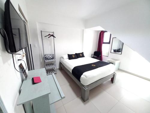 a bedroom with a bed and a flat screen tv at RCH Suite in Mexico City