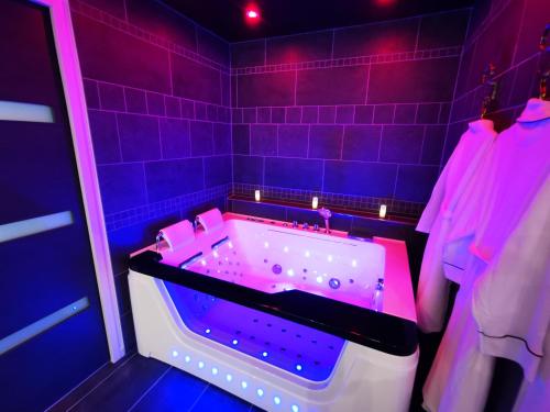 a purple bathroom with a tub with purple lights at Aux Bulles in Limoges