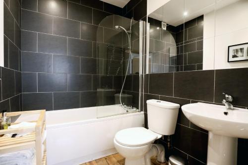 a bathroom with a toilet and a sink and a bath tub at Stable Cottage in Pateley Bridge