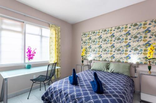 a bedroom with a bed with blue pillows on it at Hostel St Llorenc in Mexico City