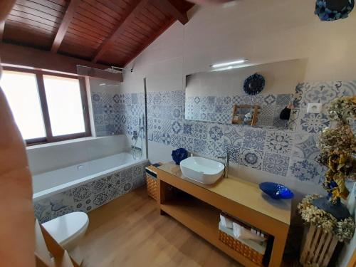 a bathroom with a tub and a sink and a toilet at Aldeia da Graça in Guimarães