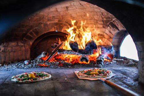 two pizzas are cooking in a brick oven at The Kitch'inn - Boutique Inn and Wine Bar in Mahone Bay