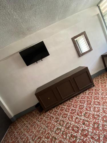 - un salon avec une télévision à écran plat dans l'établissement Hotel Oseguera, à Uruapan del Progreso
