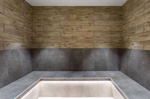 a bathtub in a room with wooden walls at Radisson Blu Hotel London Stansted Airport in Stansted Mountfitchet