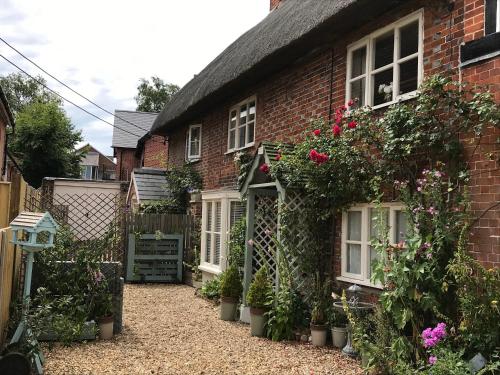 a brick house with flowers on the side of it at Chapel Cottage in Pewsey