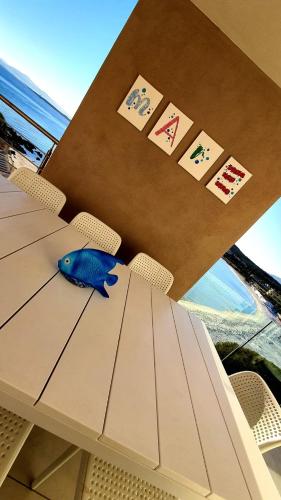 a table with a blue fish sitting on top of it at Appartamento Delfino Bianco in Golfo Aranci